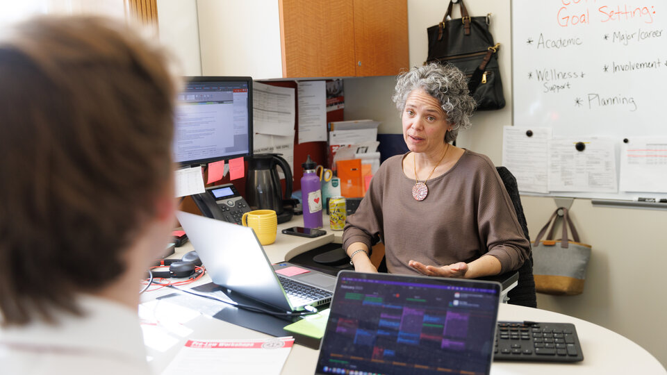 Advisor sits across student
